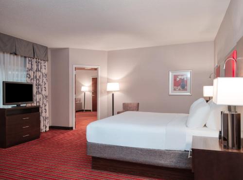 Crowne Plaza Indianapolis-Dwtn-Union Stn, an IHG Hotel في انديانابوليس: غرفة فندقية بسرير كبير وتلفزيون بشاشة مسطحة
