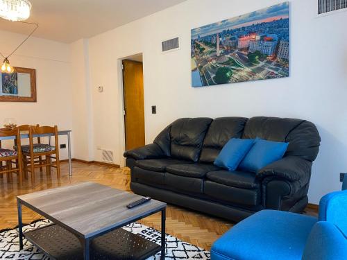 sala de estar con sofá de cuero negro y mesa en Beautiful Apartment in Las Cañitas Buenos Aires en Buenos Aires