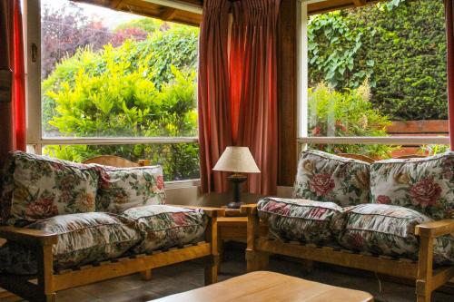 una sala de estar con 2 sofás y una ventana grande en Complejo Ciprés en San Martín de los Andes