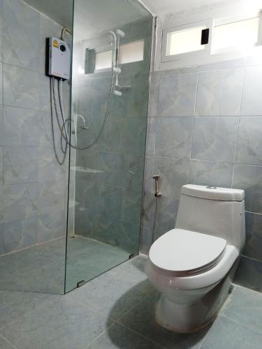 a bathroom with a toilet and a shower at The Green Vale B&B in Ban Na Chaliang