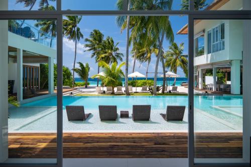 a view of the pool from the lobby of a resort at Amilla Maldives in Kihaadhoo
