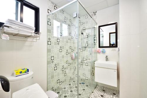 a bathroom with a glass shower with a toilet at Fengru B&B in Taitung City