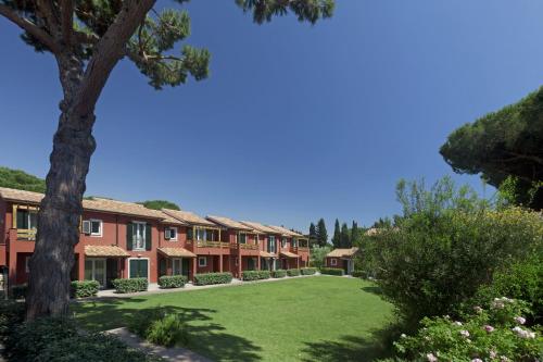 una fila de edificios de apartamentos con un patio verde en Residence Pineta, en Albinia