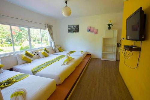 two beds in a room with a large window at Aurora Resort Khao Yai in Mu Si