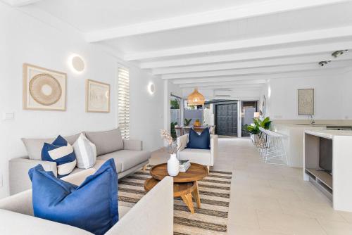 a living room with a couch and a table at Edgewater Collection by Stay Noosa in Noosa Heads