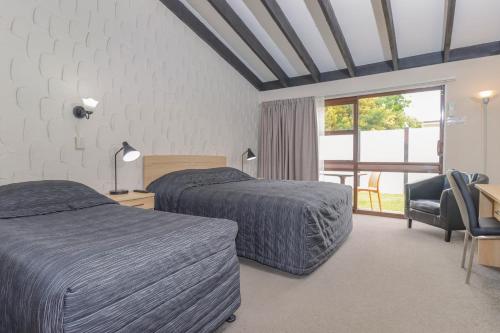 a hotel room with two beds and a window at Aztec Motel in Palmerston North