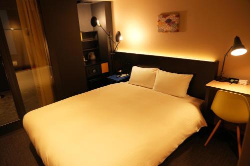 Habitación de hotel con cama blanca y escritorio en Nplus HOTEL Higashikanda-akihabara en Tokio