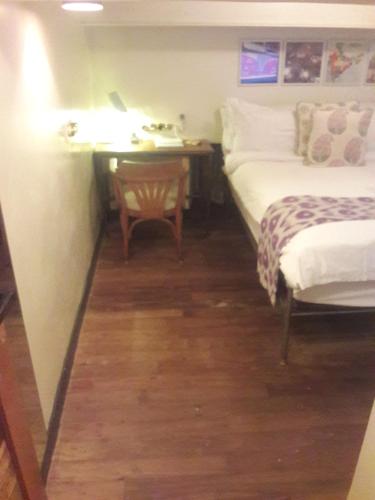 a room with two beds and a desk with a lamp at Abode Bombay in Mumbai
