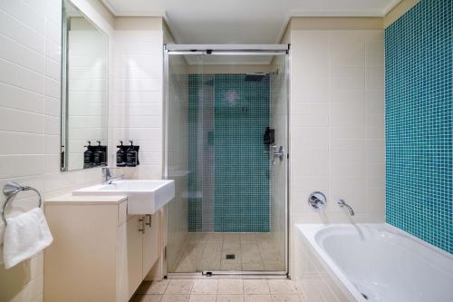 y baño con bañera, lavamanos y ducha. en Mantra The Observatory, en Port Macquarie