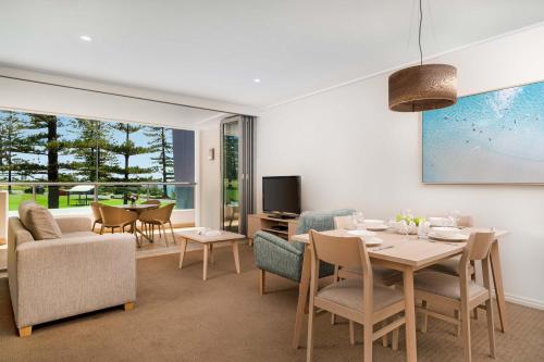 a living room with a table and chairs at Mantra The Observatory in Port Macquarie