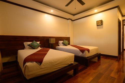 a hotel room with two beds in a room at Lux Hotel in Luang Prabang