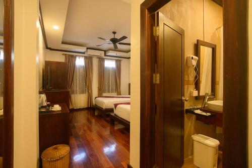 a room with a bedroom with a bed and a bathroom at Lux Hotel in Luang Prabang