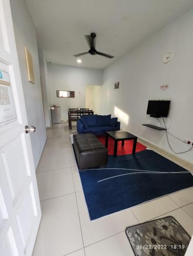 a living room with a blue couch and a table at OYO Homes 90679 Bahari Homes in Malacca