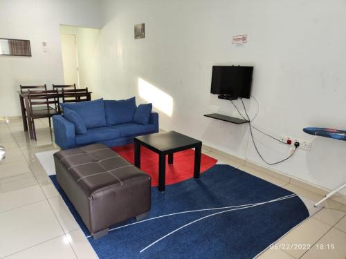 a living room with a blue couch and a stool at OYO Homes 90679 Bahari Homes in Malacca