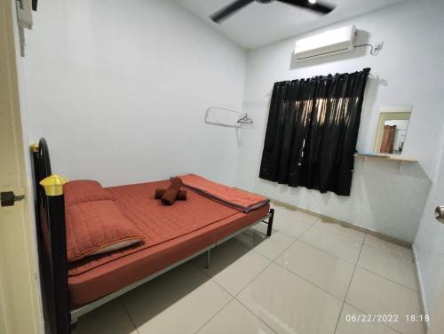 a small bed in a room with a window at OYO Homes 90679 Bahari Homes in Melaka
