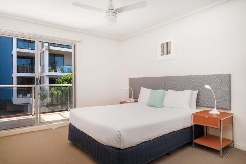 a bedroom with a bed and a large window at Mantra The Observatory in Port Macquarie
