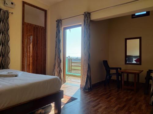 a bedroom with a bed and a large window at Corbett Rejoice Home Stay in Jhirna