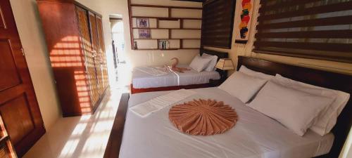 um quarto com duas camas e um cisne na cama em Balay Sa Bukid 2 Bedroom em Boracay
