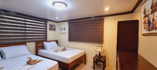 a small room with two beds and a window at Balay Sa Bukid 2 Bedroom in Boracay