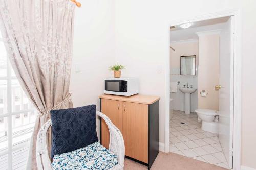 a bathroom with a chair and a microwave on a counter at Settlers Hotel York in York