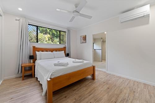 a white bedroom with a large bed and a window at Highview Atherton in Atherton