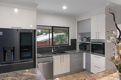a kitchen with white and gray cabinets and a window at Highview Atherton in Atherton