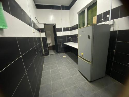 y baño con nevera pequeña y lavamanos. en Roomstay Gemilang, en Kuala Terengganu