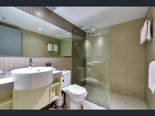 a bathroom with a toilet and a sink and a shower at Pandanas Apt 3 (Darwin CBD, Harbour views) in Darwin