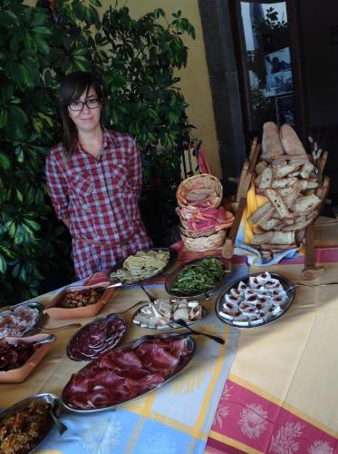 a woman sitting at a table with plates of food at Agriturismo Borgo San Nicolao in Randazzo