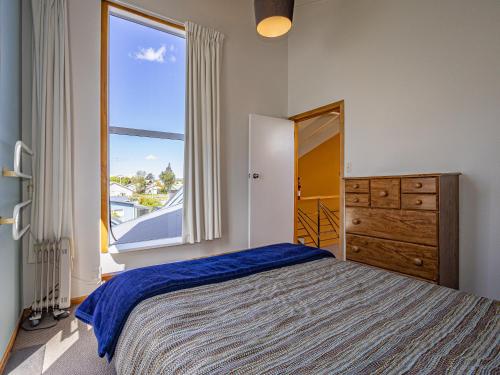 a bedroom with a bed and a large window at Ariki - National Park Holiday Home in National Park