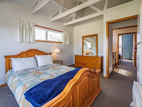 a bedroom with a bed and a dresser and a mirror at Ariki - National Park Holiday Home in National Park