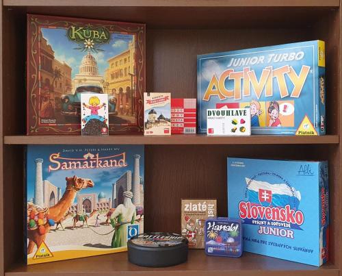 a book shelf with books and games on it at Vila Doliny in Konská