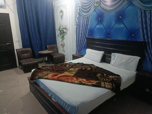 um quarto com uma cama com uma parede azul em New Hajveri Hotel Lahore em Lahore