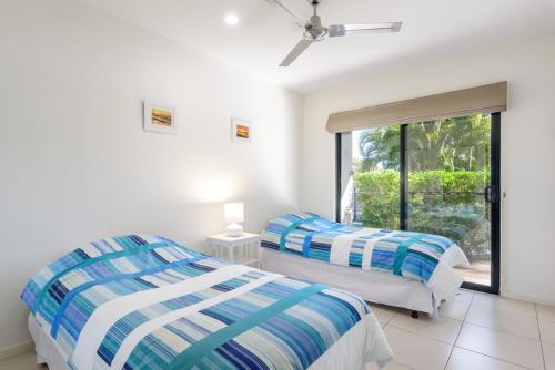two beds in a room with a window at Rainbow Surf 1 in Rainbow Beach