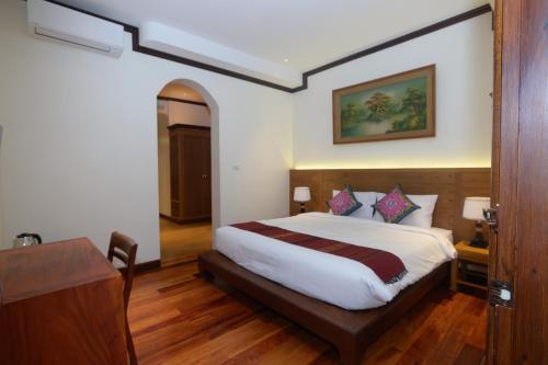 a hotel room with a bed and a desk at Lux Hotel in Luang Prabang