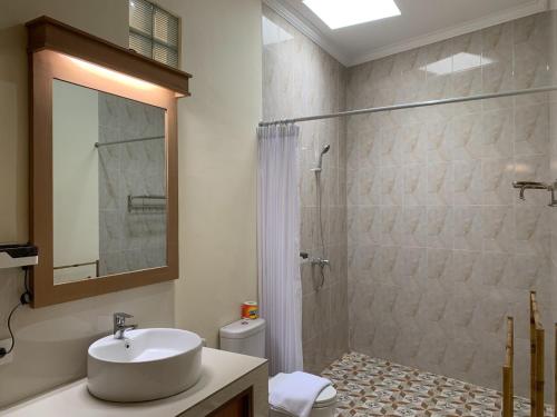 a bathroom with a sink and a shower and a toilet at Betesda Guest House in Canggu