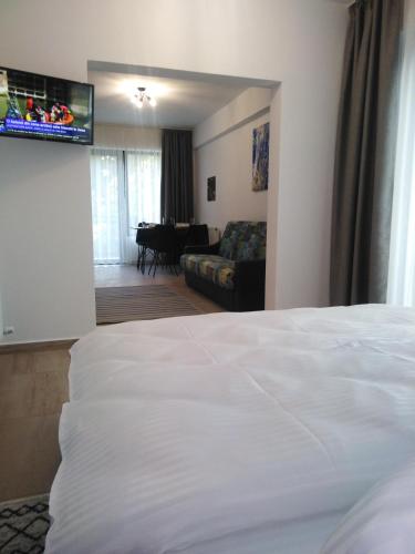 a bedroom with a white bed and a living room at Danifeld Inn in Voronet