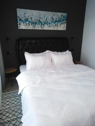 a white bed with a black headboard and white pillows at Danifeld Inn in Voronet
