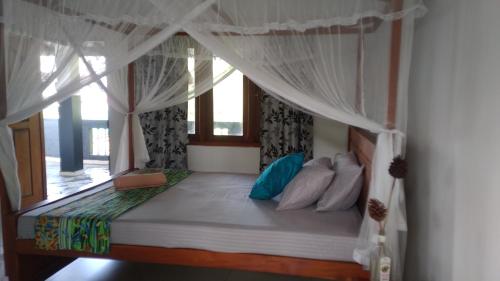 a bedroom with a bed with a canopy at The Swiss Lankan in Ahangama