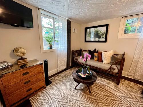 uma sala de estar com um sofá e uma televisão em Dougan Suites em Portland