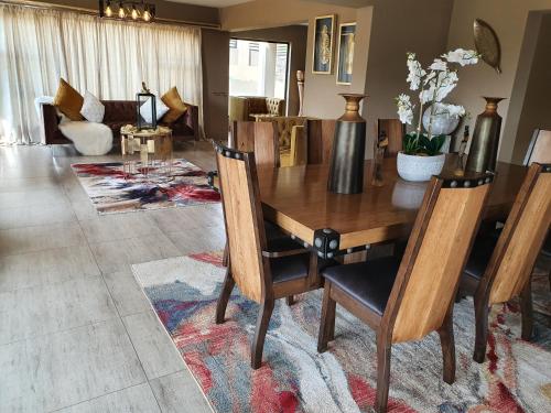 a dining room with a wooden table and chairs at Mohau Accommodation in Elandsfontein