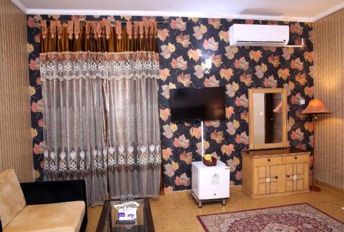 uma sala de estar com uma cortina e uma televisão em Premier inn Mall Lahore em Lahore