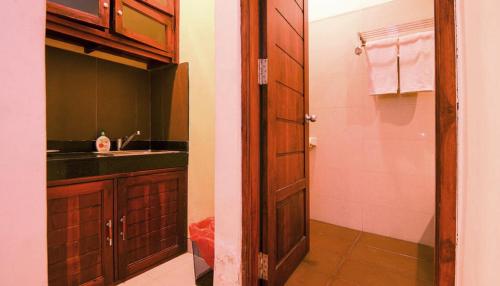 a bathroom with a sink and a shower and a door at Kuta Paradise 777 in Legian