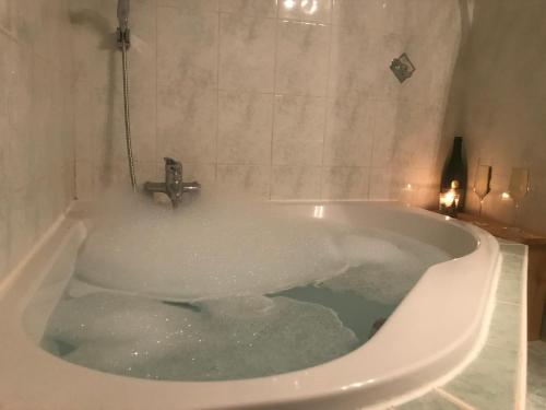 a bath tub filled with water in a bathroom at Les Marmottes 2 in Orcières