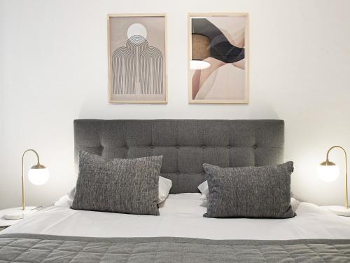 Sanders Stage - Enchanting Four-Bedroom Apartment Near Nyhavn في كوبنهاغن: غرفة نوم بسرير مع صورتين على الحائط