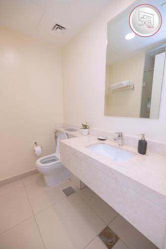 a bathroom with a toilet and a sink and a mirror at 5 bedroom Villa - Dubai Hills in Dubai