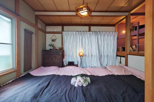 Una cama grande en un dormitorio con flores. en Otsuka House, en Tokio