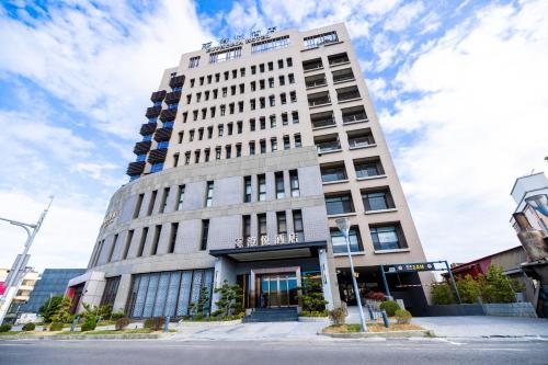 a tall white building on a city street at Euphoria Hotel Lukang in Lugang