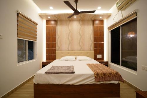 a bedroom with a bed with a ceiling fan at MARARI FARM HERITAGE INN in Mararikulam