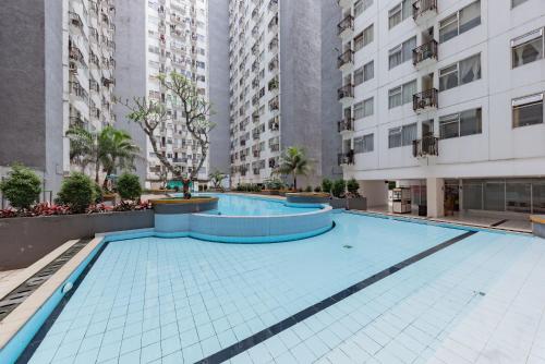 an empty swimming pool in a building with tall buildings at RedDoorz Apartment @ Jarrdin Cihampelas in Bandung